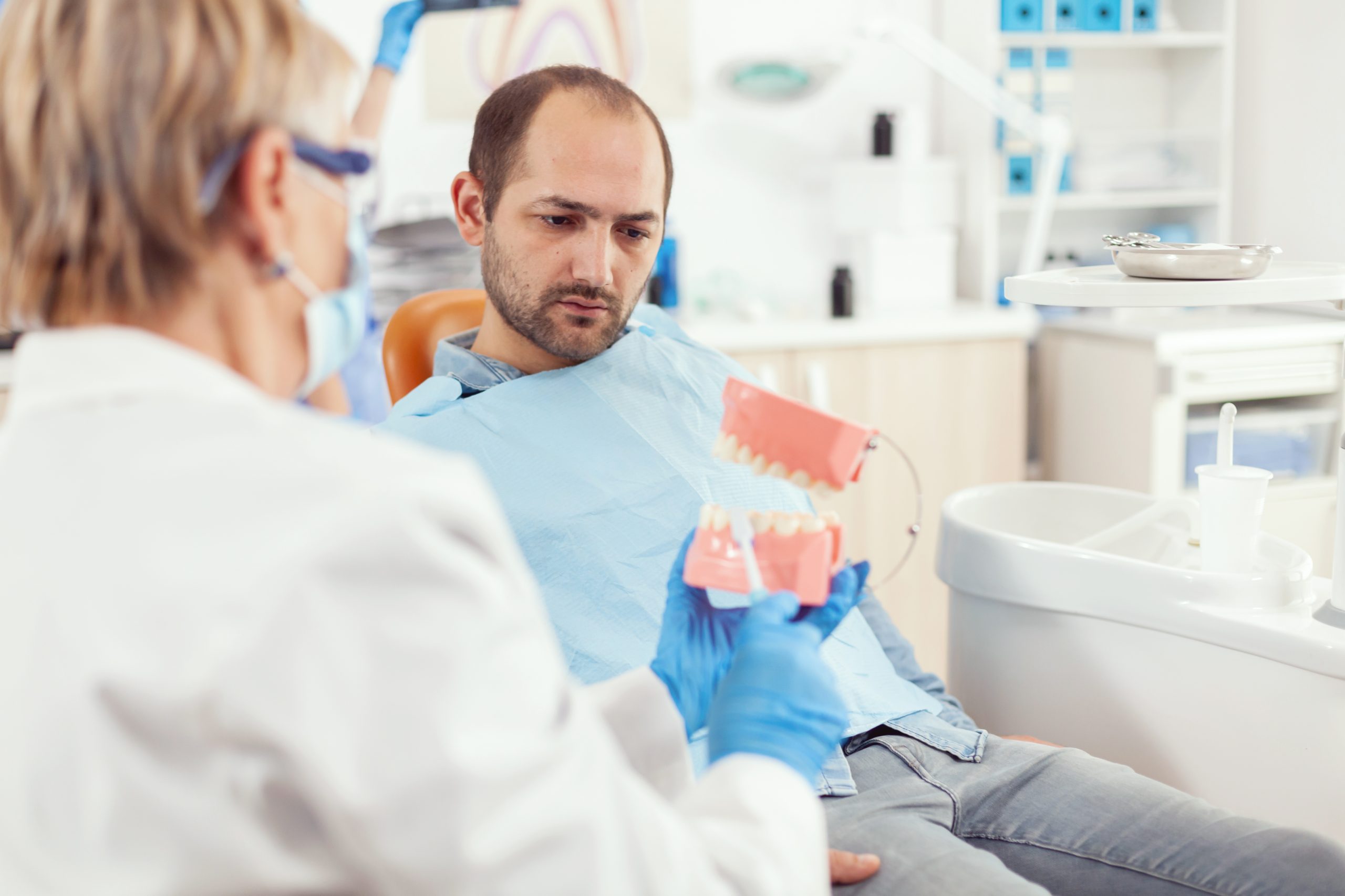Dentist comparing complete and partial dentures with a patient