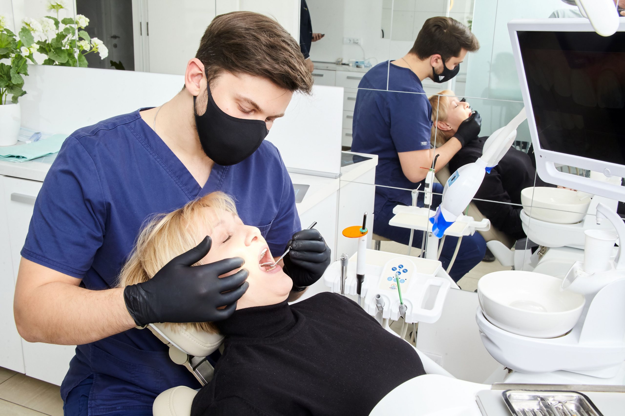 Dentist comparing in-office and at-home teeth whitening options with a patient